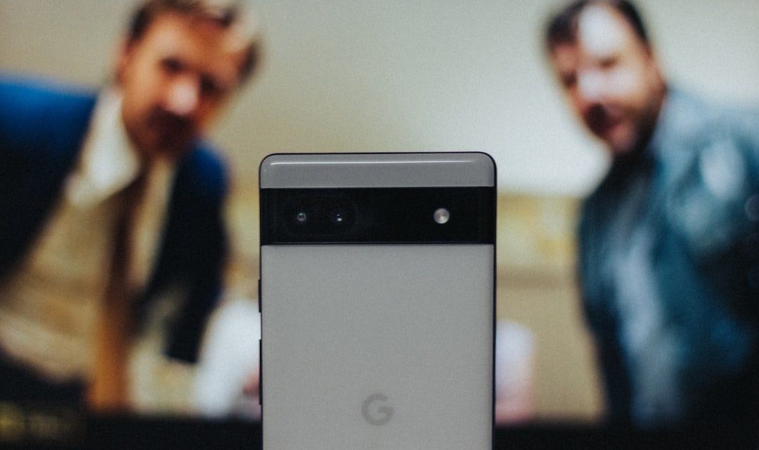a close up of a cell phone near a television