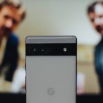 a close up of a cell phone near a television