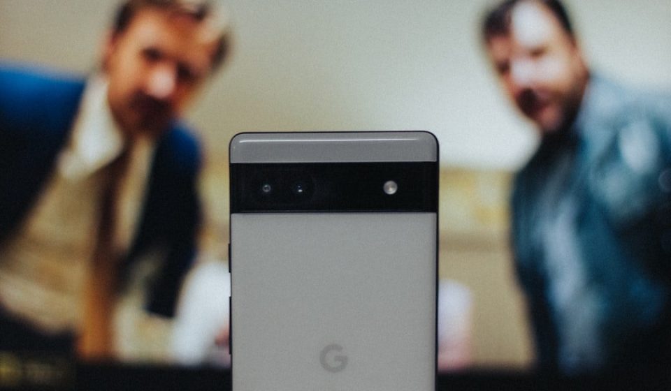 a close up of a cell phone near a television