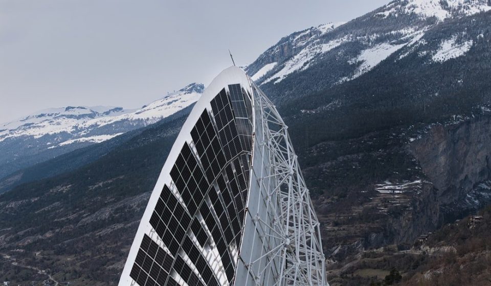 Modern solar panel structure against snowy mountains