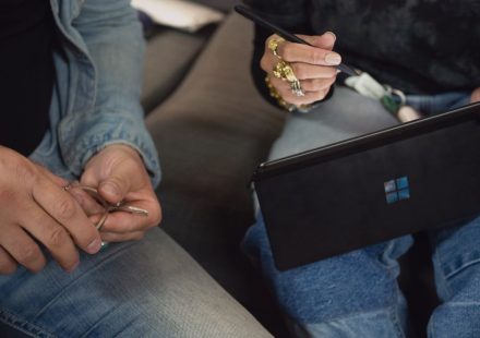 person in blue denim jeans holding Surface device