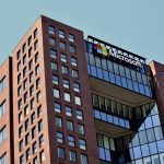 a tall brick building with windows and a sky background