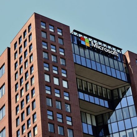 a tall brick building with windows and a sky background