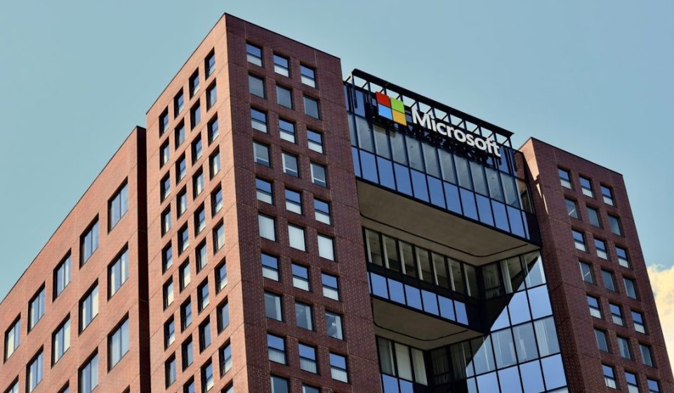 a tall brick building with windows and a sky background