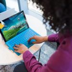 woman in purple sweater using laptop