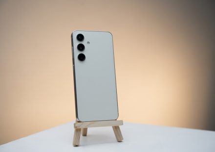 a white cell phone sitting on top of a wooden stand