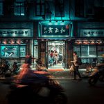 motorcycles and people passing by at night time