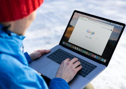 person in blue long sleeve shirt using macbook pro