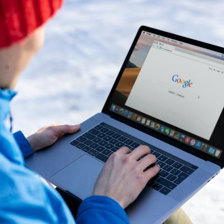 person in blue long sleeve shirt using macbook pro