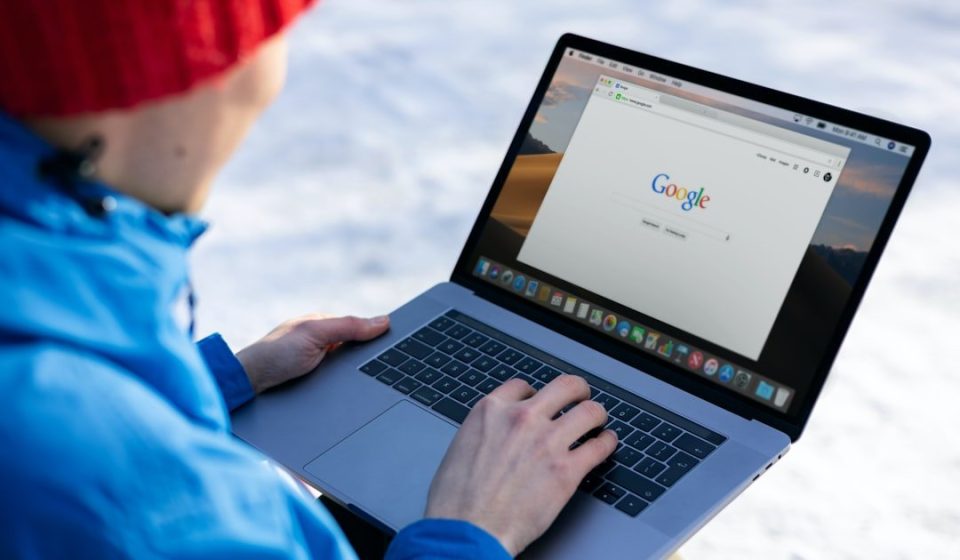 person in blue long sleeve shirt using macbook pro